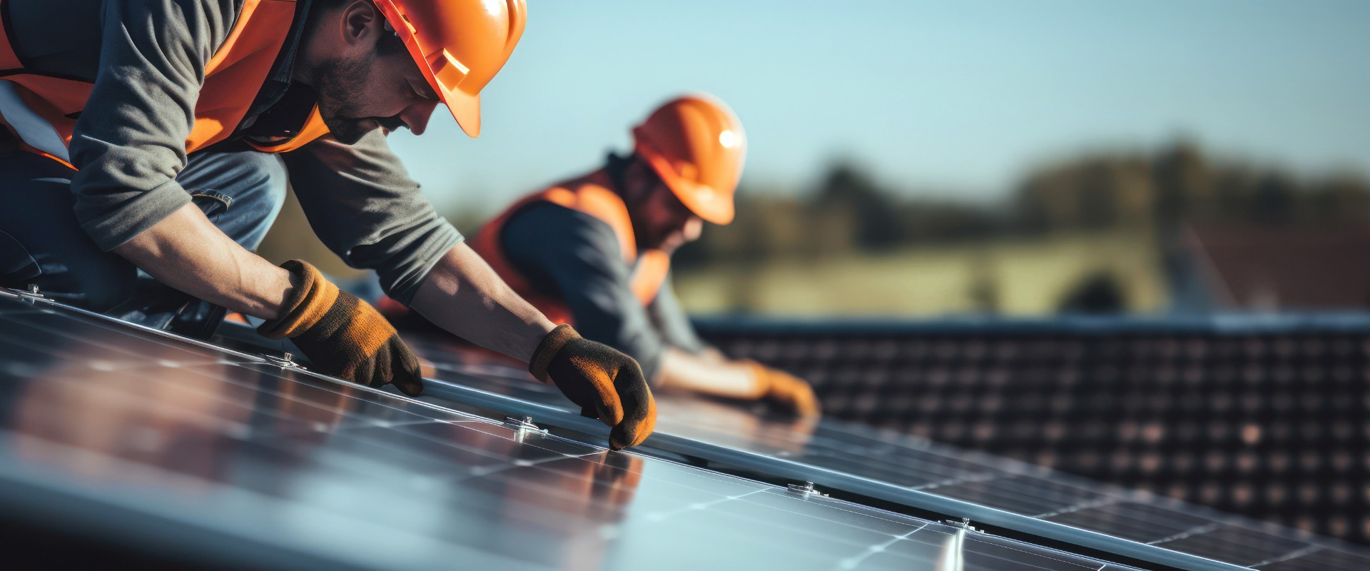 Installation von Solarmodulen. Bauarbeiter mit Schutzhelm arbeiten auf dem Dach